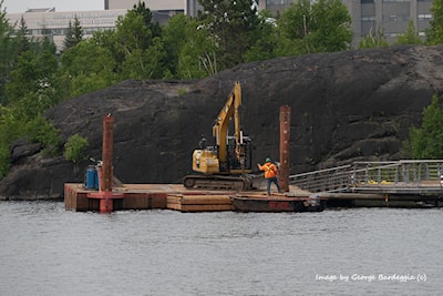 Using backhoe to reconnect the dock section.