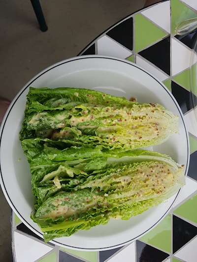 A simple Ceasar salad dressing brushed on a split head of romain grilled hot.