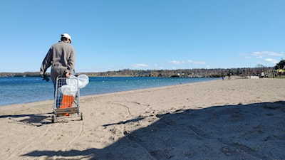 Local artist Jill Price walking and cleaning Centennial Beach